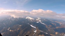 Paragliding fly above snowy alpine mountains in sunny spring, Adrenaline adventure flight