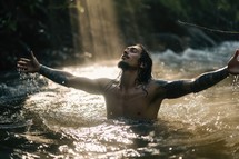 Man with arms outstretched in worship in a river. Beauty and power of Faith. 