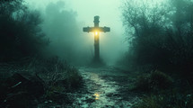 Cross on the path. Cross with a warm light in a cold, foggy morning.