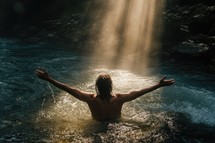 Man with arms outstretched in worship in a river. Beauty and power of Faith. Christian concept.	