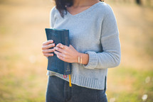 young woman holding a Bible against her chest 