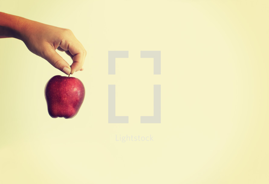 hand holding a red apple.