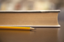 pencil and book on a desk. 