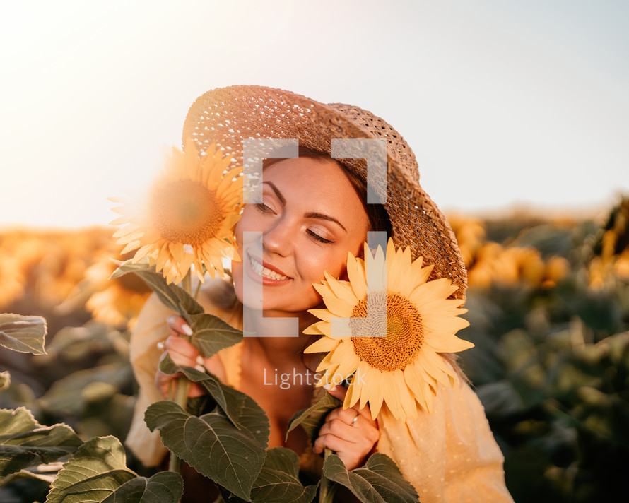 Beautiful young woman in straw hat posing with sunflowers. Blooming field. Happy smiling girl. Trendy outfit, vintage retro style