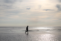 man walking on wet sand on a beach 