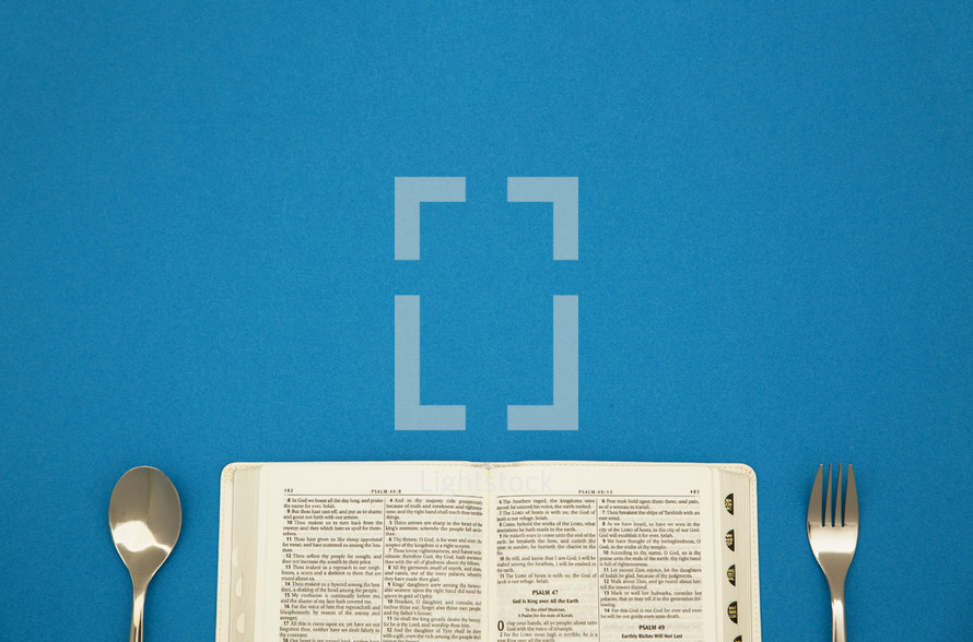 an open Bible with fork and spoon 