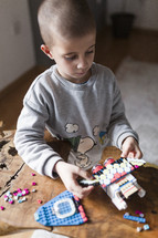 Little boy playing with lego blocks.