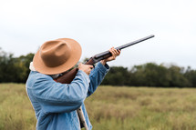 a man pointing a shotgun 