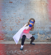 a little girl dressed up like a super hero 