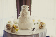 A wedding cake surrounded by flowers