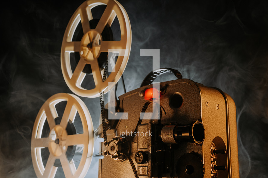  White film reels rotating.Old-fashioned 8mm movie projector playing bobbin tape