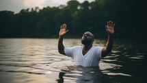 Baptism. Handsome black man in a white t-shirt in worship in the lake at sunset