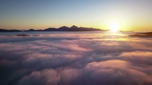 Beautiful aerial sunset above foggy clouds in mountains nature Drone shot Hyper lapse
