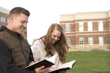 students reading books on campus 