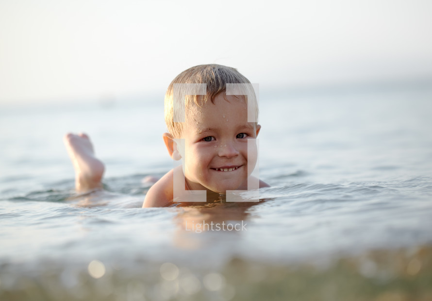 Smiling little boy in the sea