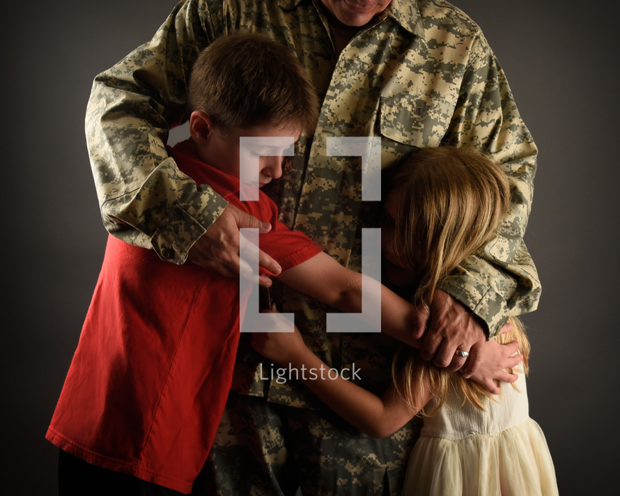 a military father hugging his children 