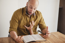 hand grabbing a man who is reading a Bible