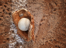 baseball glove and baseball on a baseball diamond 