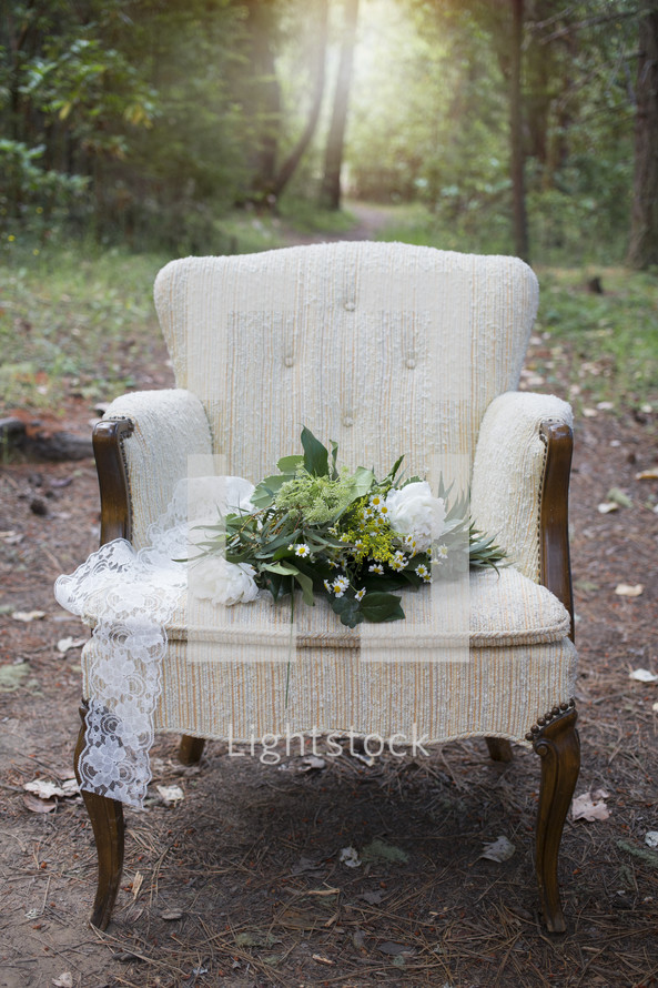 a bouquet of flowers in a chair in a forest 