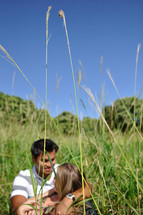 couple snuggling in tall grass 