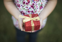 a girl holding a wrapped gift 