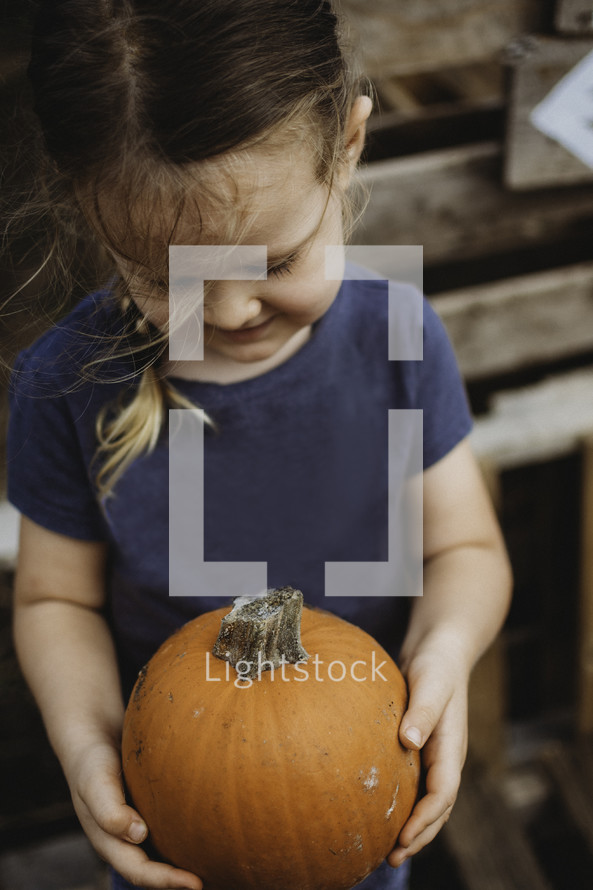 girl holding a pumpkin 