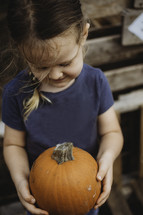 girl holding a pumpkin 