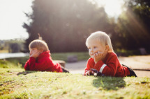 toddlers laying in grass 