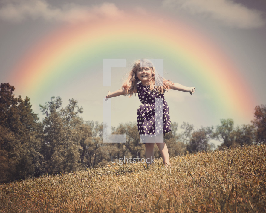 a child running under a rainbow 