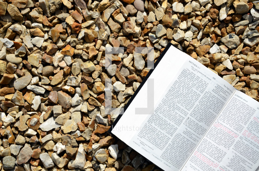 open Bible on gravel 