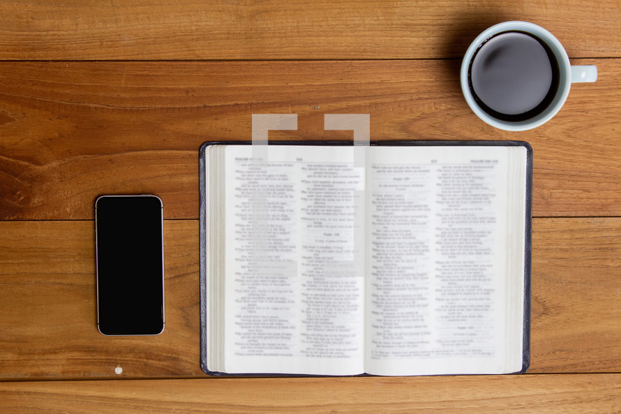 open Bible, cellphone, and coffee cup 
