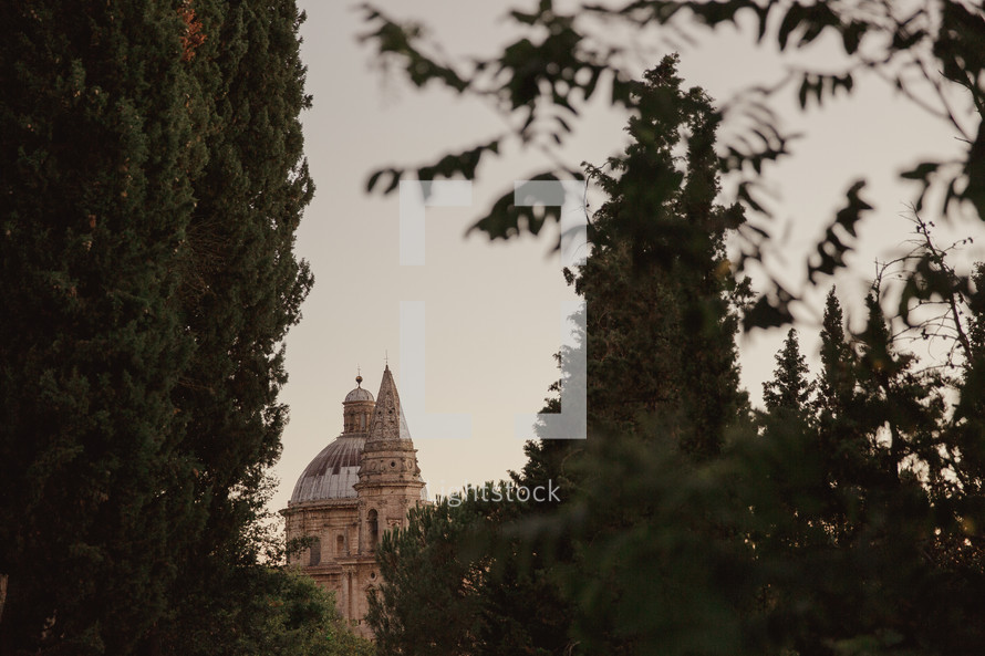 view of a dome on a church in Italy through the trees 