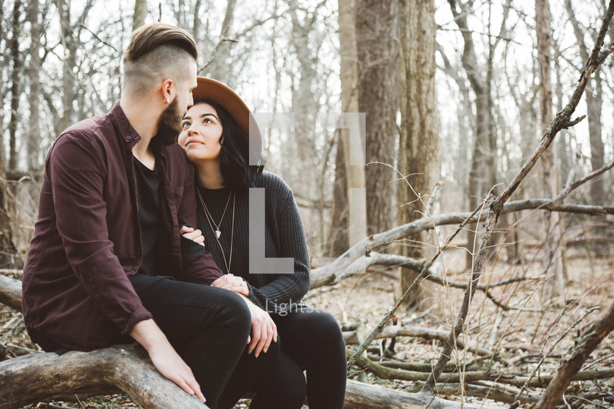 couple sitting together outdoors in the woods 