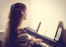 teenage girl playing a piano 