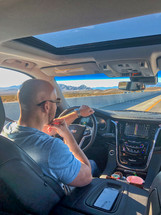 a man driving a SUV on a road trip 