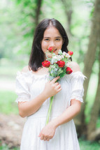 a woman holding red and white roses 