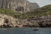 people swimming in the sea along an Italian shore 