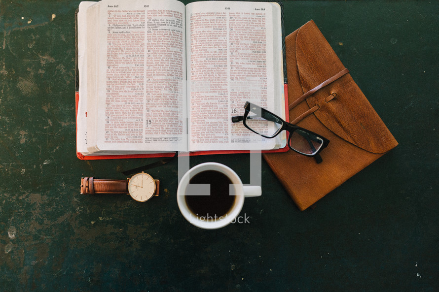 pen on a Bible, watch, coffee cup, reading glasses, journal