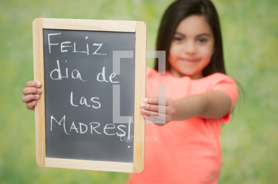 girl holding a Feliz dis de Las Madres sign 