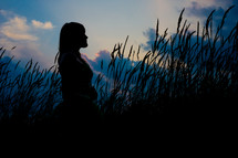 silhouette of a woman standing in a field 
