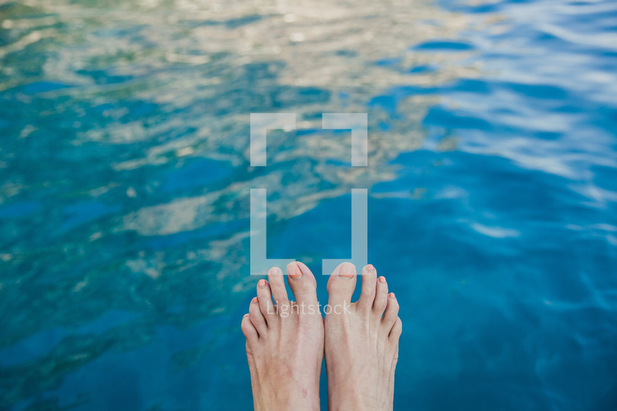 feet hanging over water in Italy 