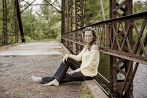 woman sitting on a bridge 
