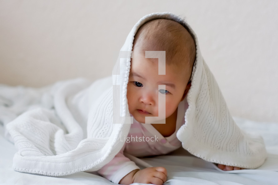 an infant under a blanket 