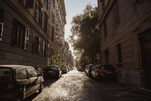 cars parked along narrow cobblestone streets in Rome 