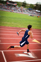 man running on a track in a relay race 
