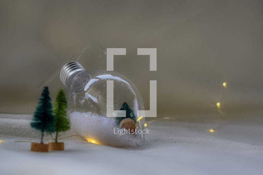 bulb ornament and miniature Christmas trees on a white background 