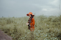 a woman in an orange hat standing outdoors 