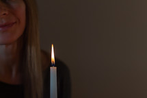 a woman holding a white candle 
