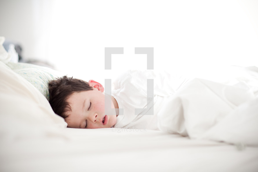 boy asleep in a light-filled room