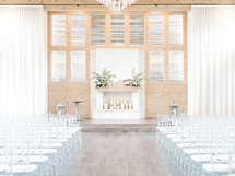 rows of white chairs at a wedding venue 